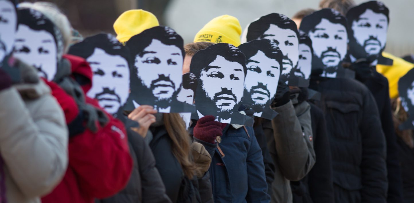 A group of Amnesty members with masks of Taner Kilic