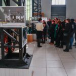 На передньому плані: фото у рамці. На задньому плані - група людей роздивляється фотовиставку